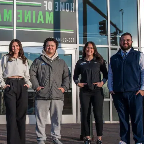 UNE business students pose in front of the Cross Insurance Arena in Portland